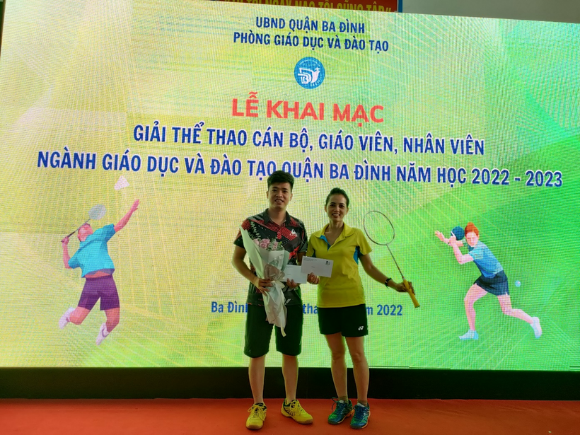 A person and person posing for a picture in front of a sign

Description automatically generated with medium confidence