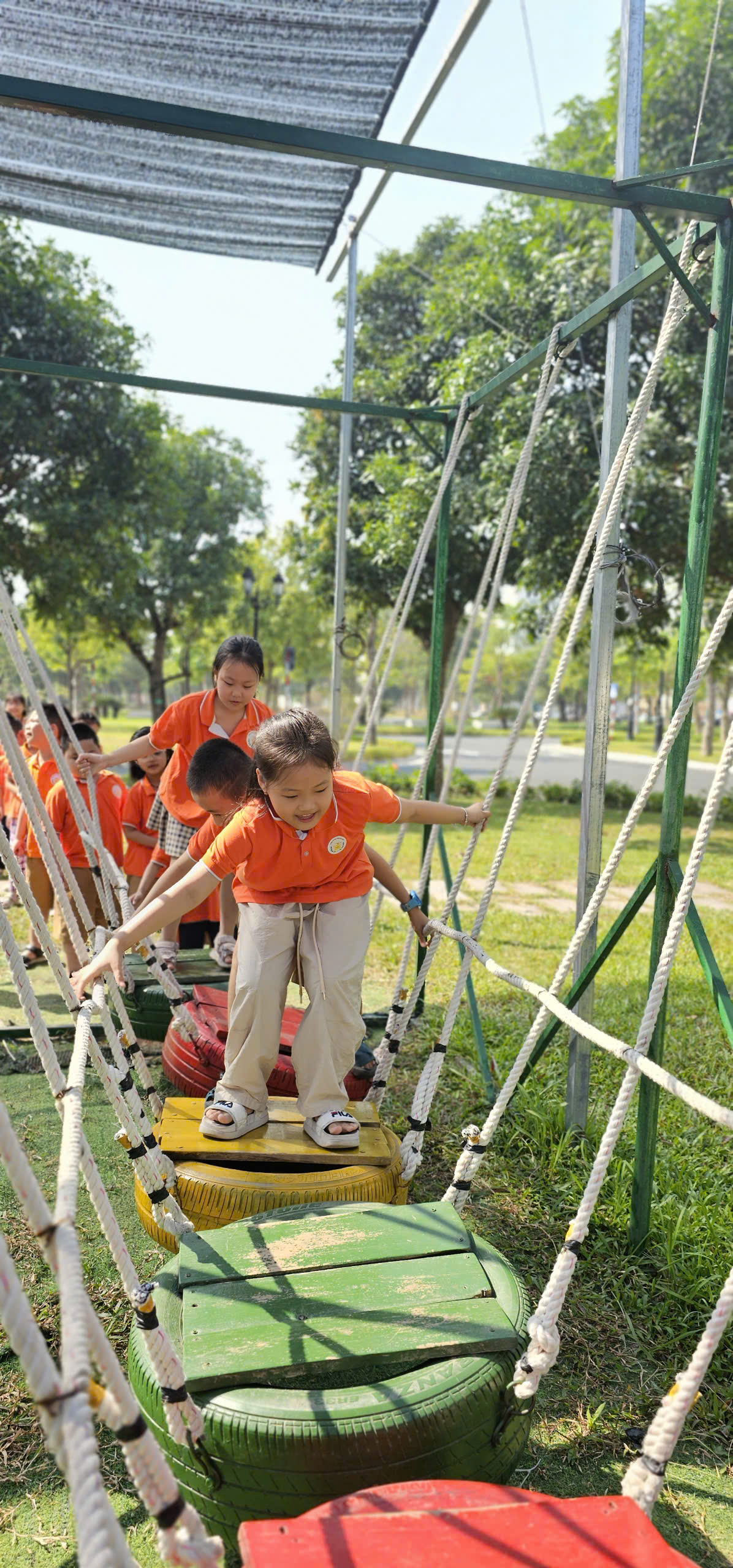 A group of children playing on a swing set

Description automatically generated