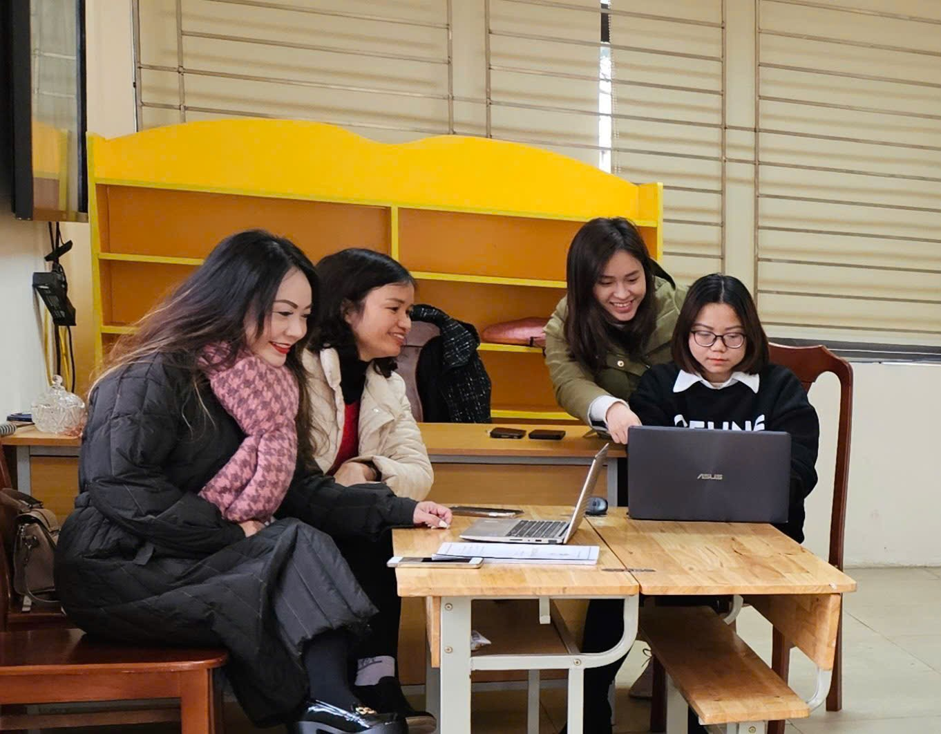 A group of women sitting at a table looking at a computer

AI-generated content may be incorrect.