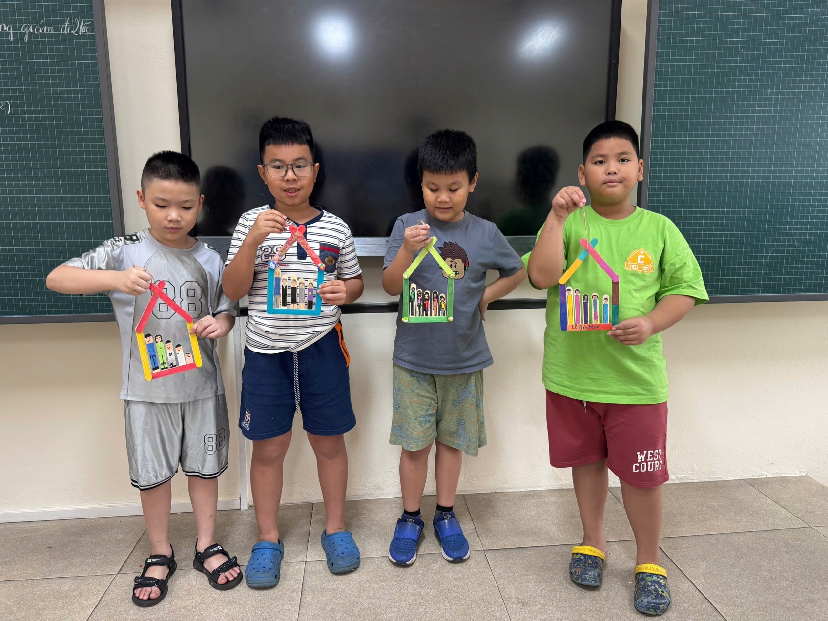 A group of boys holding up paper houses

AI-generated content may be incorrect.