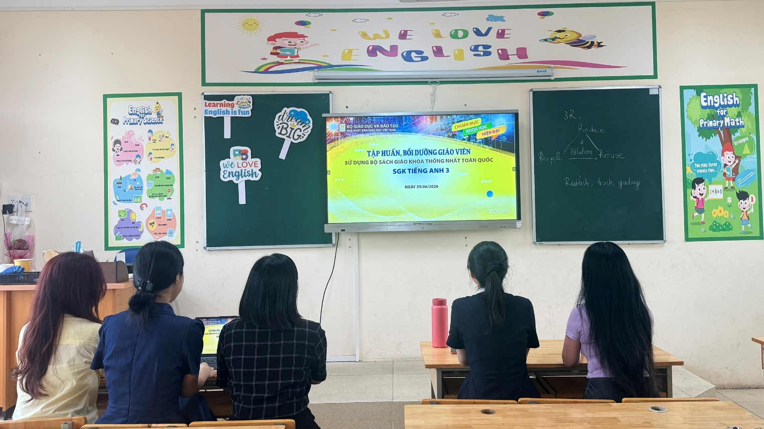 A group of people sitting at desks in a classroom
Description automatically generated